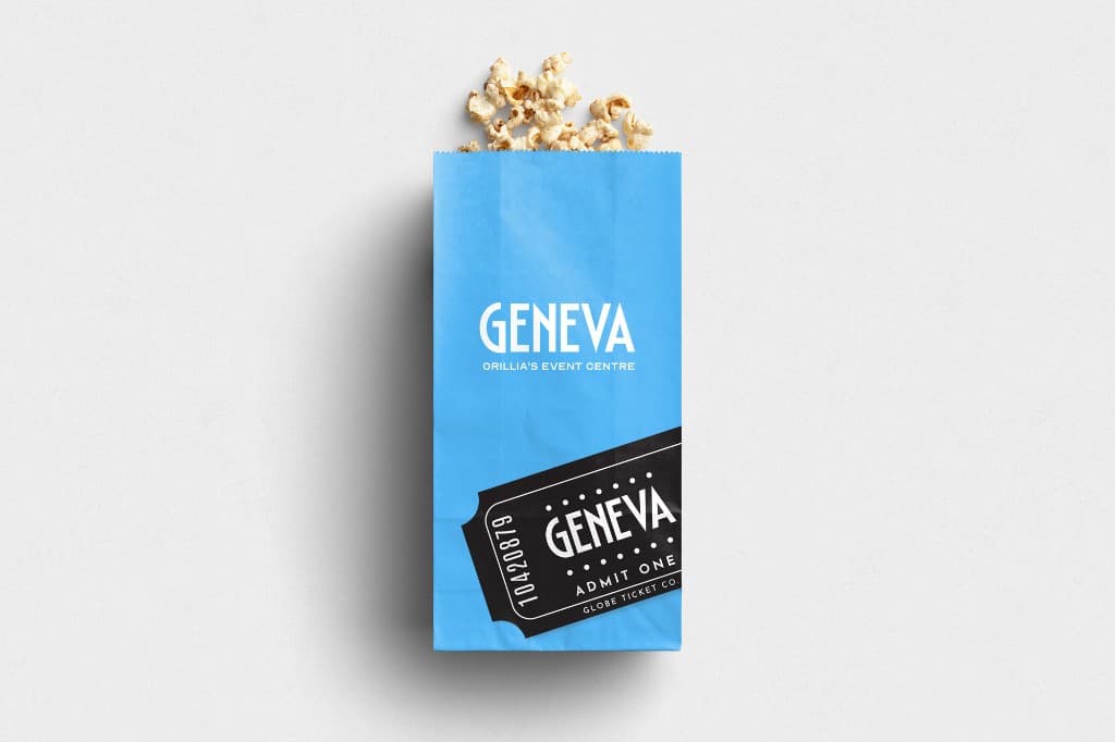 A light blue popcorn bag printed with GENEVA, Orillia’s Event Centre, and a black ticket graphic reading Admit One.