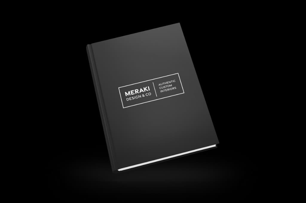 A black hardcover book with the Meraki Design Co. wordmark and the line Authentic Custom Interiors on the cover.