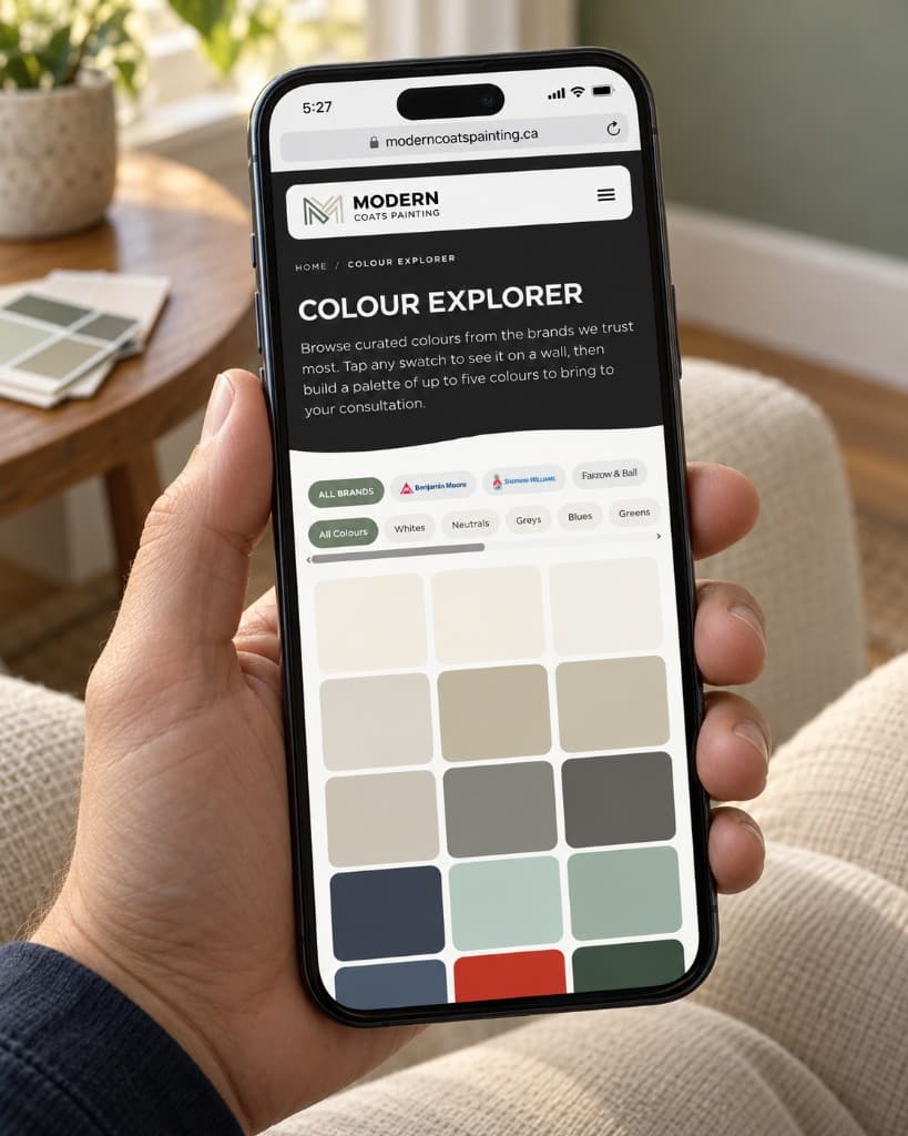 A hand holding a phone that shows a Modern Coats Painting colour-explorer page: a heading, brand filters, and a grid of paint-colour swatches.