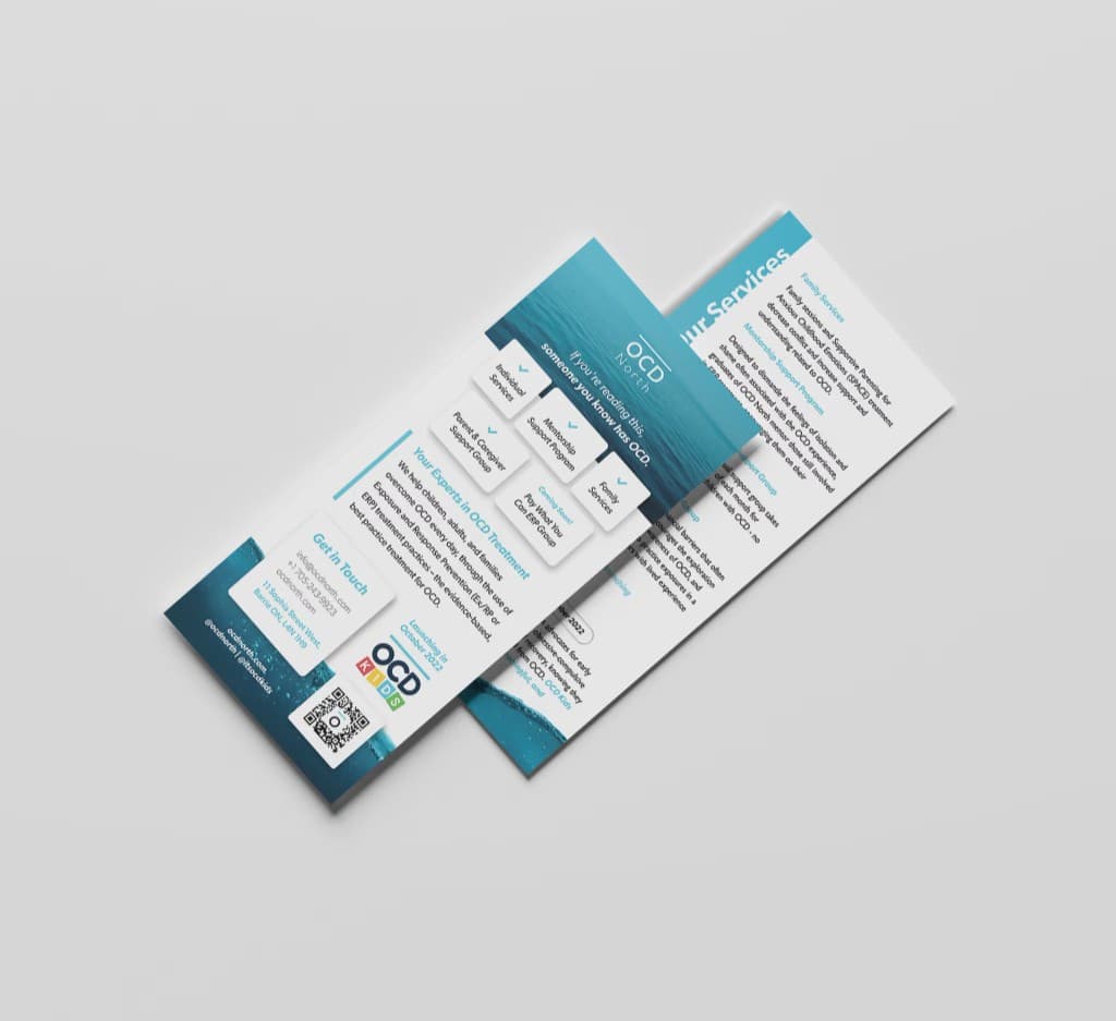 Two OCD North rack cards on a pale surface: a sea-horizon header with the wordmark, service tiles, and a contact panel.