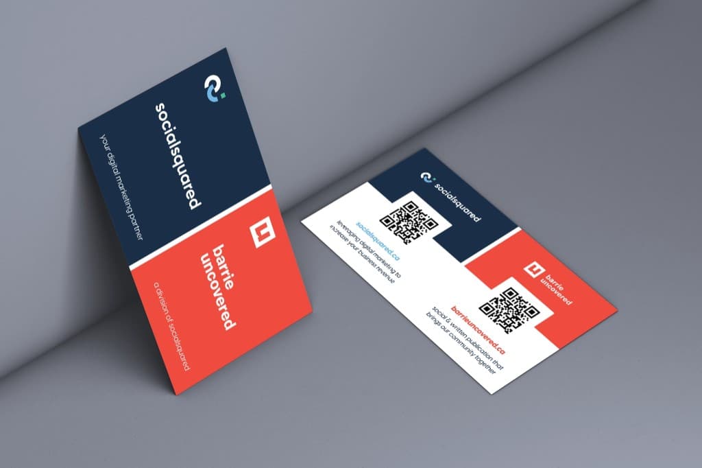 Two dual-branded business cards: the front split diagonally between navy SocialSquared and red Barrie Uncovered panels, the back white with a QR code and web address for each brand.
